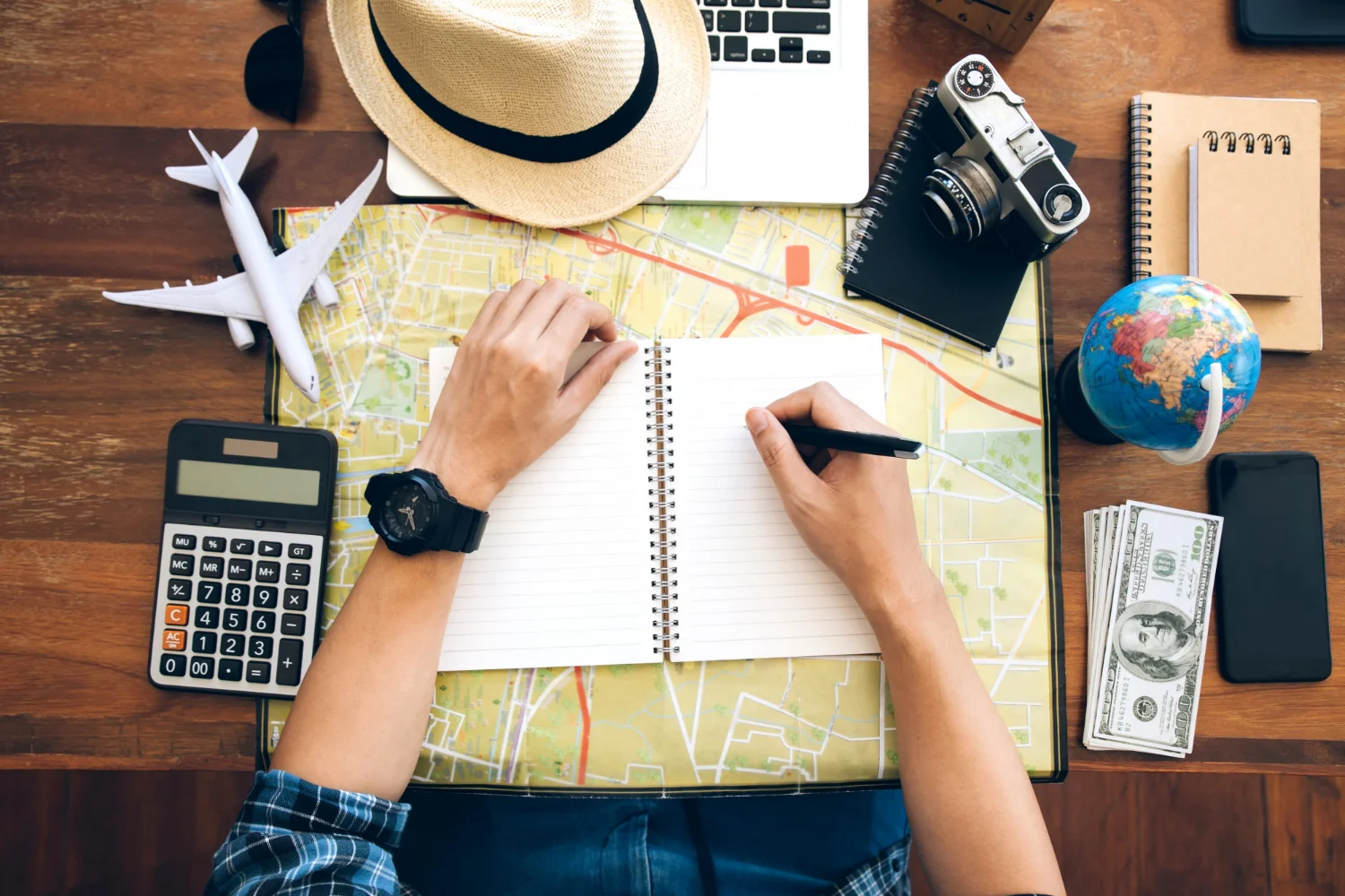 persona escribiendo en su diario de viajes